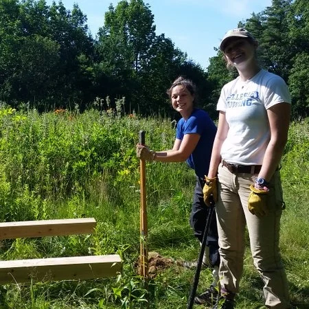2017 Regional Field Team members, Beanie and Michaela, install interpretive signage at Merrymeeting Fields Preserve.