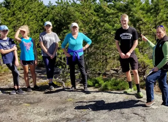 Thomas (in the Bowdoin t-shirt) led a guided hike of the trail and shared how he worked with KELT staff to plan and complete trail construction.
