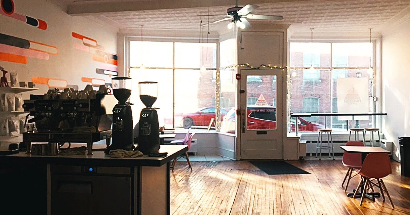Interior of coffee shop, looking into the space and out the windows from behind the counter