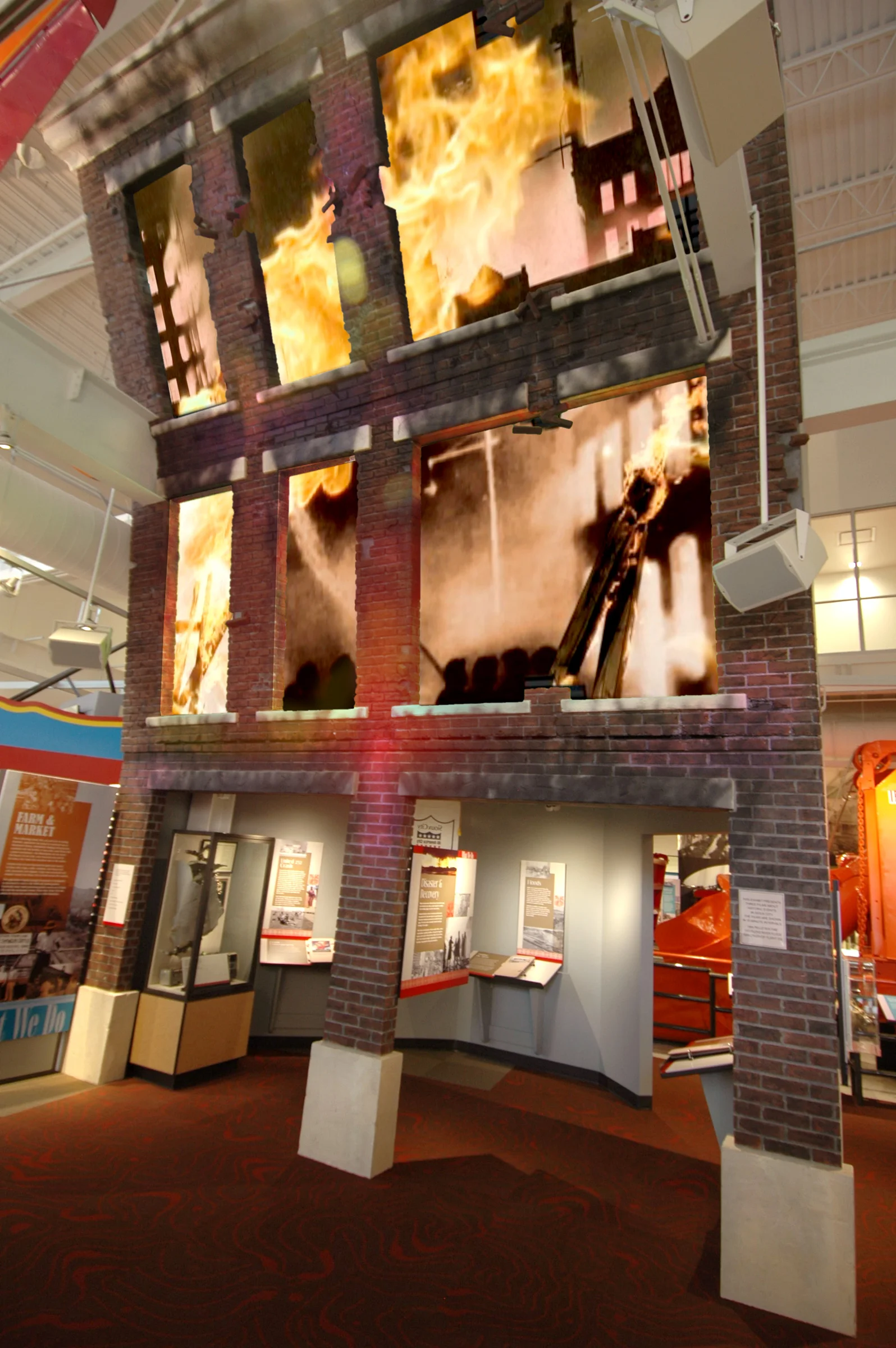 The windows of a three-story building façade showcase a rear-projection multimedia presentation, Disaster and Recovery, featuring fires, floods and the disaster of United Airlines Flight 232.