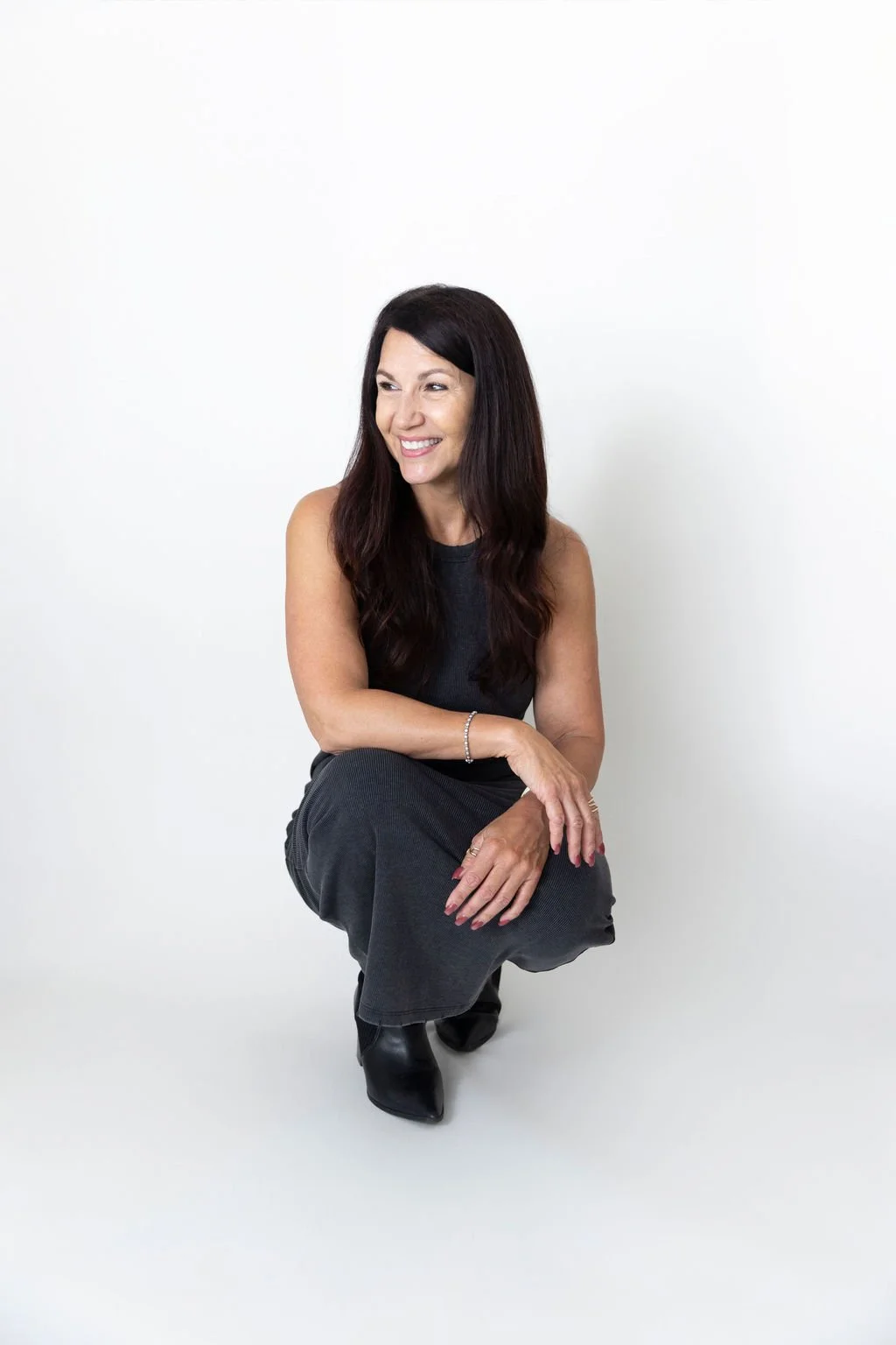 woman crouching down with a white backdrop