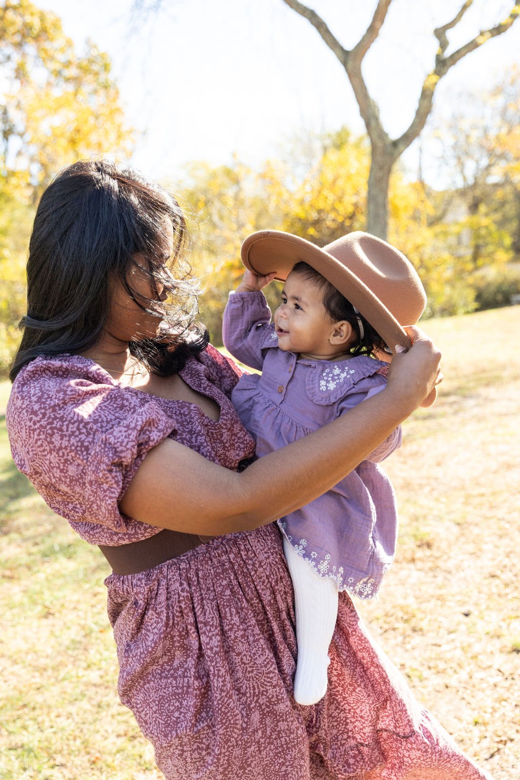mom putting her hat on her toddler at islip grange park in Sayville ny family photos by Danielle Sheridan
