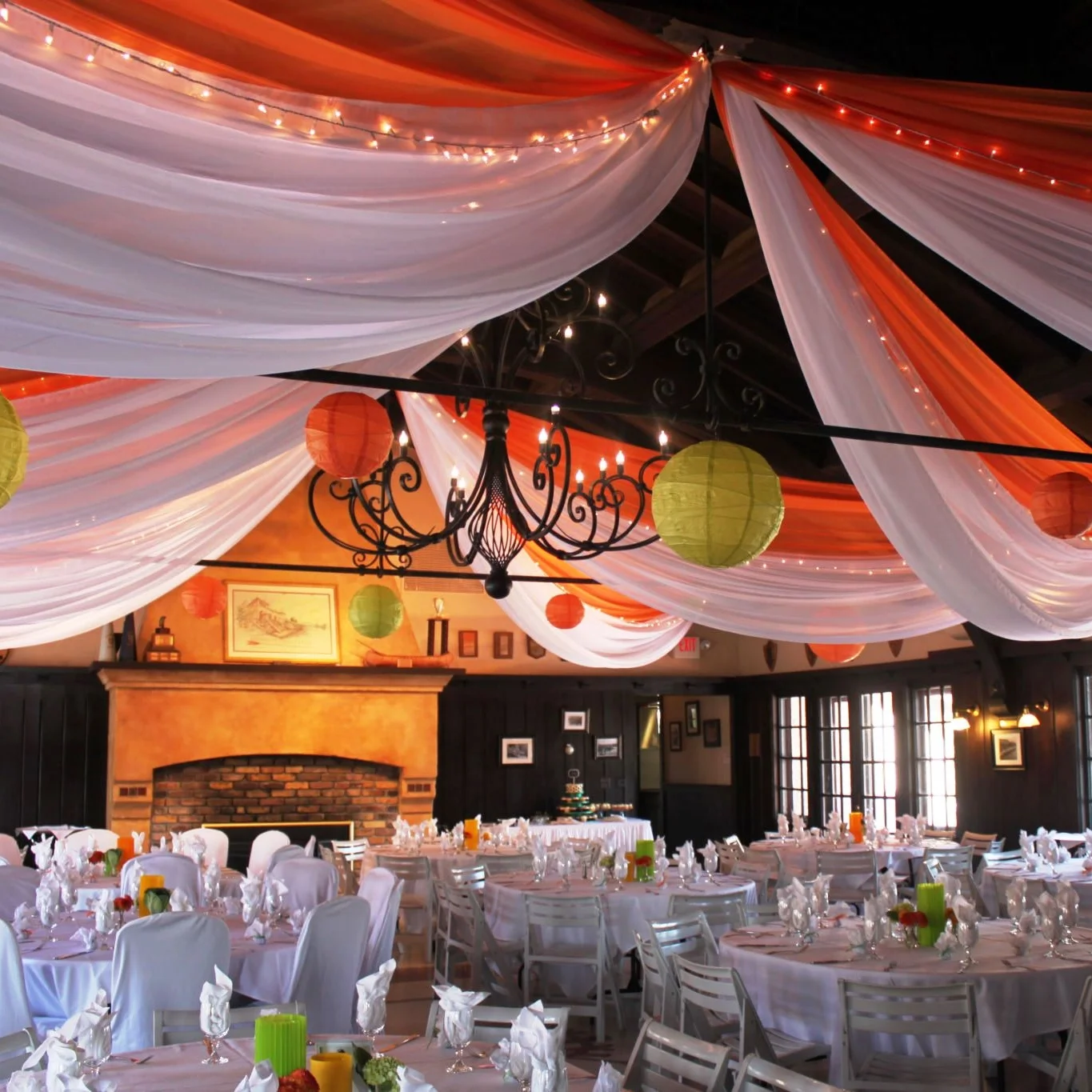 orange and white ceiling draping with twinkle lights