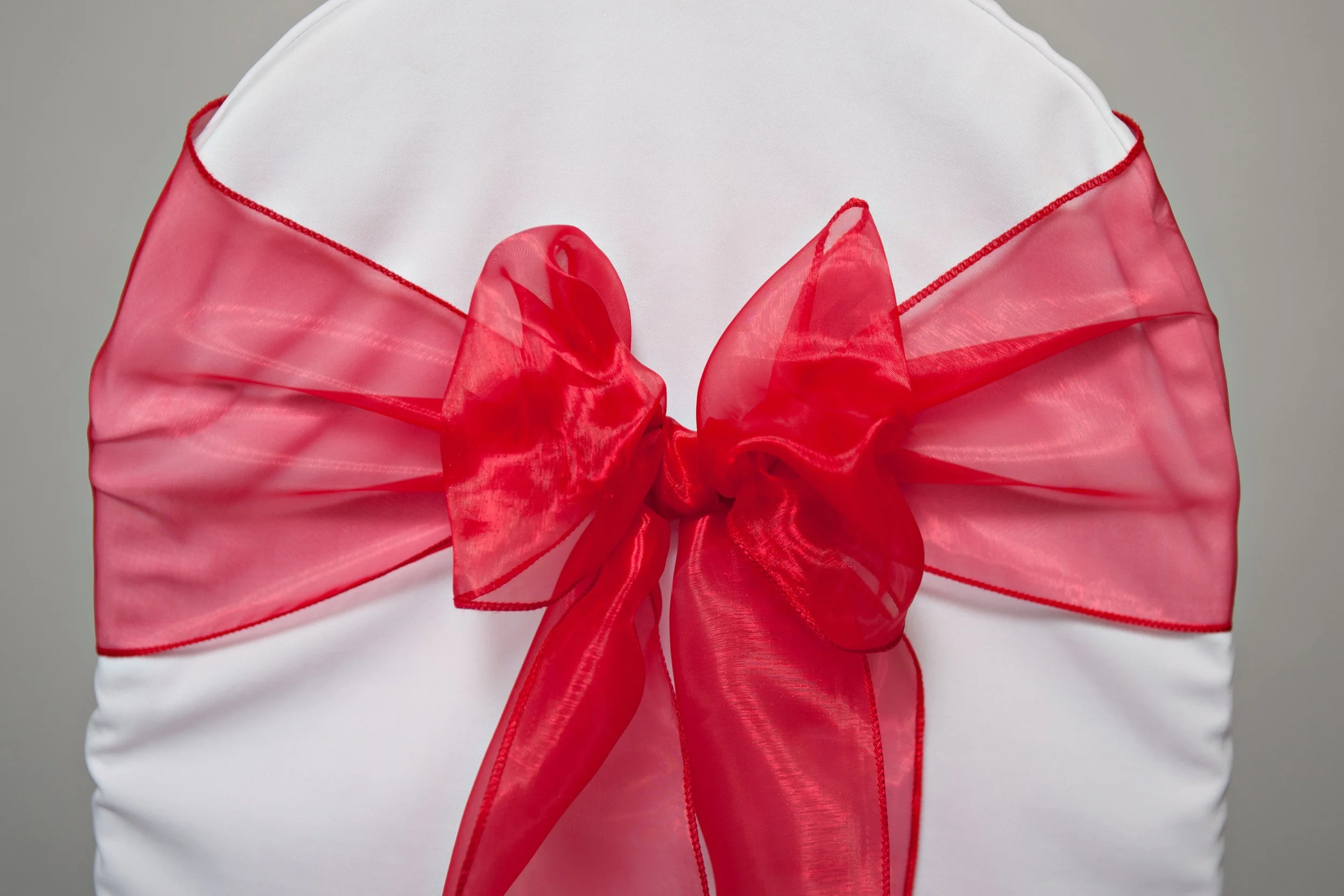 red organza sash tied in a bow