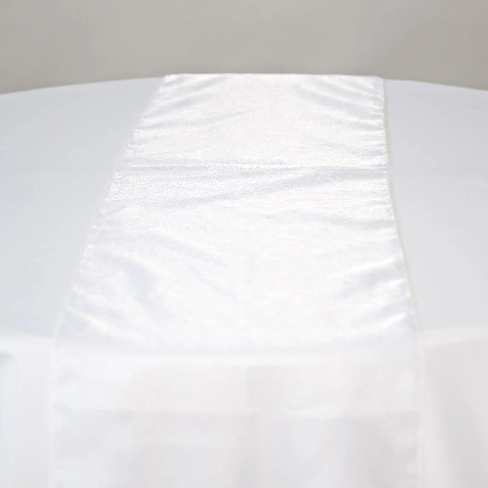 white shimmer organza table runner on table