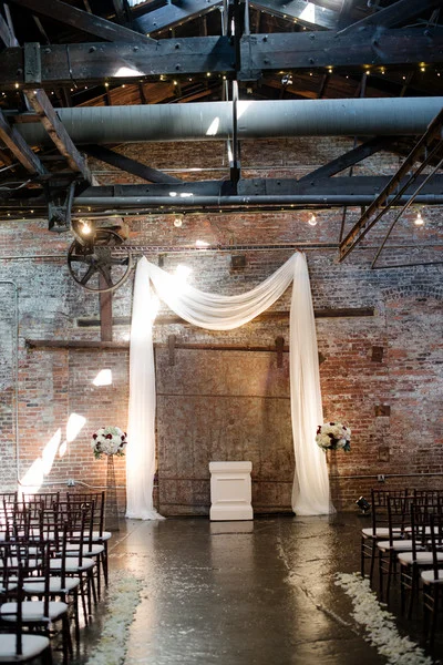 wedding draping hung for ceremony against brick wall