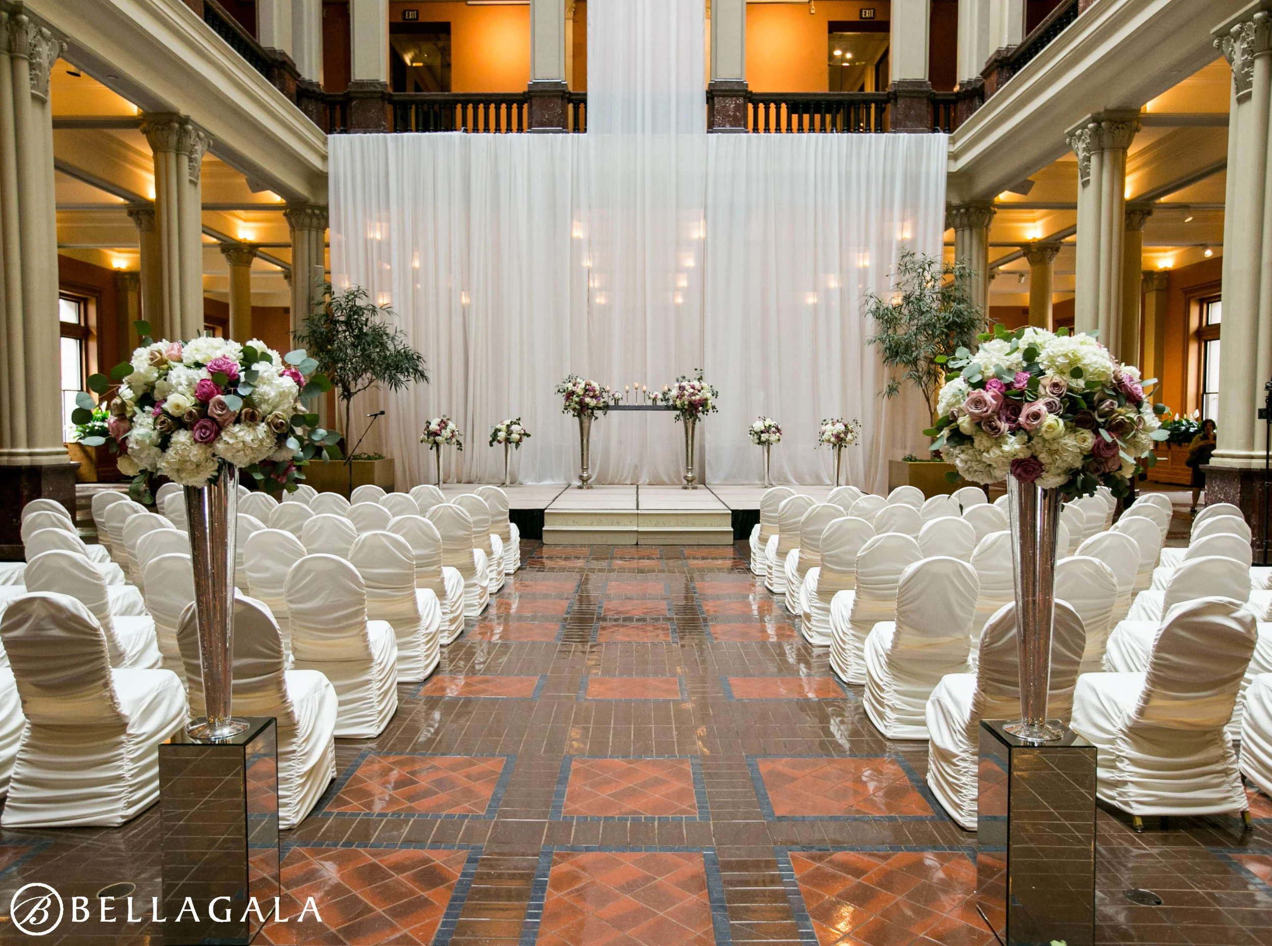 ivory rouge chair covers at wedding ceremony with draping backrop