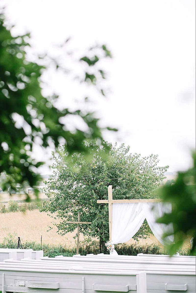 draping on an outdoor farm venue arch with floral tied back