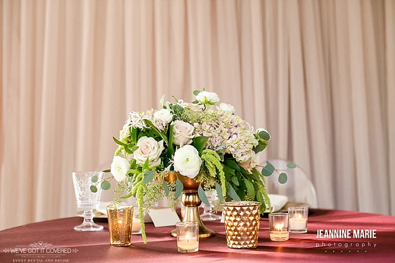 Elegant gold, red, green, white and taupe colors mixed for a wedding reception table