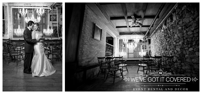 black and white shot of cozy wedding with chandelier lighting and stone wall