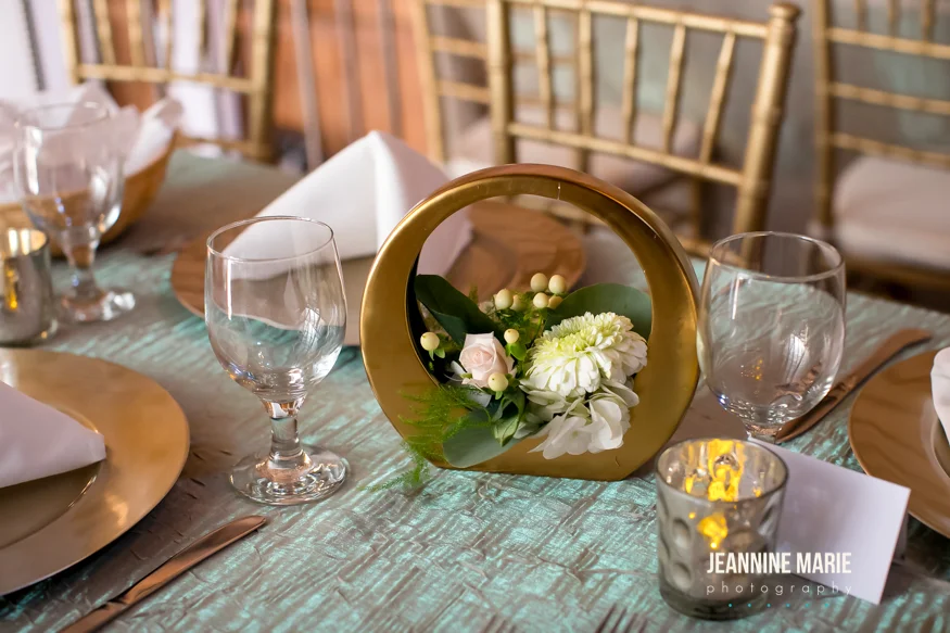 Shimmery table linen with gold accents and candles on guest tables at a wedding reception