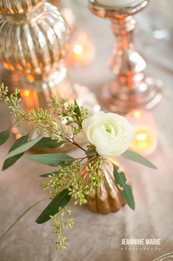 mercury bud vase holding a flower next to candlesticks