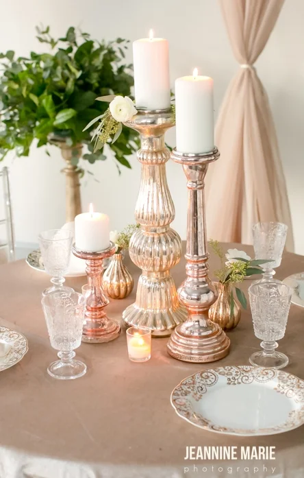 Mercury glass candlestick centerpieces on a champagne linen