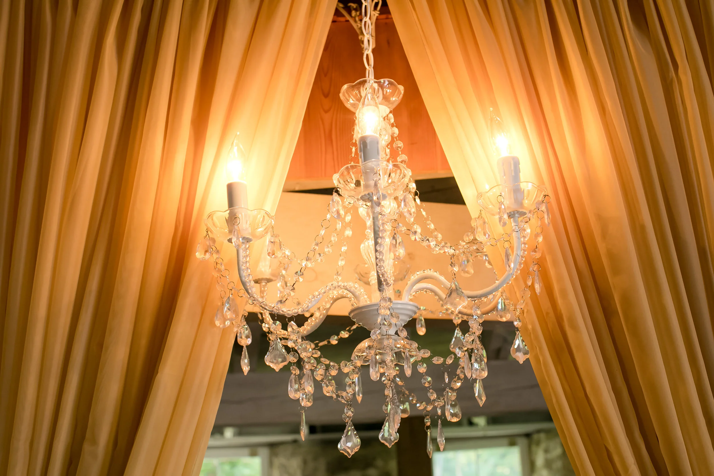 crystal chandelier on a taupe curtain backdrop