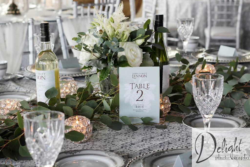 wedding reception inspiration with lace linens and table numbers displayed in front of white roses