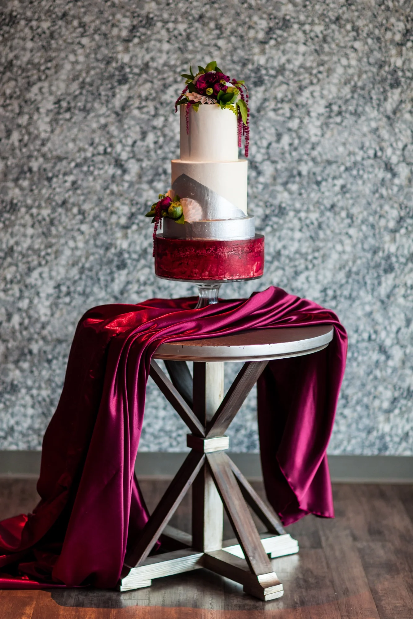 wedding cake with burgundy linen draped over table