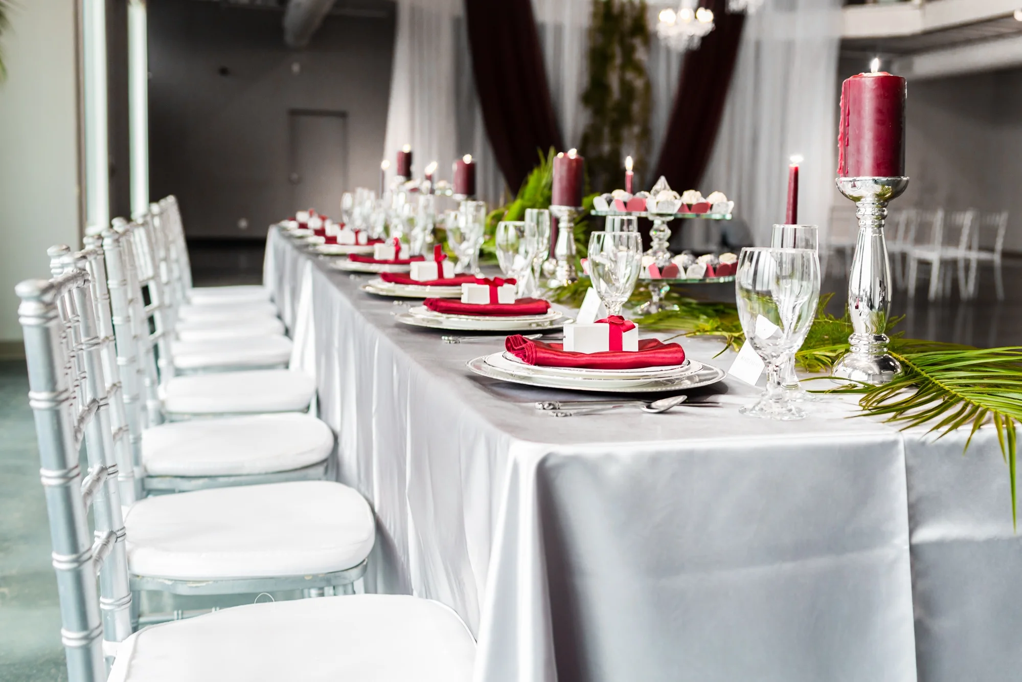 Head table set up with burgundy accents and fern greenery