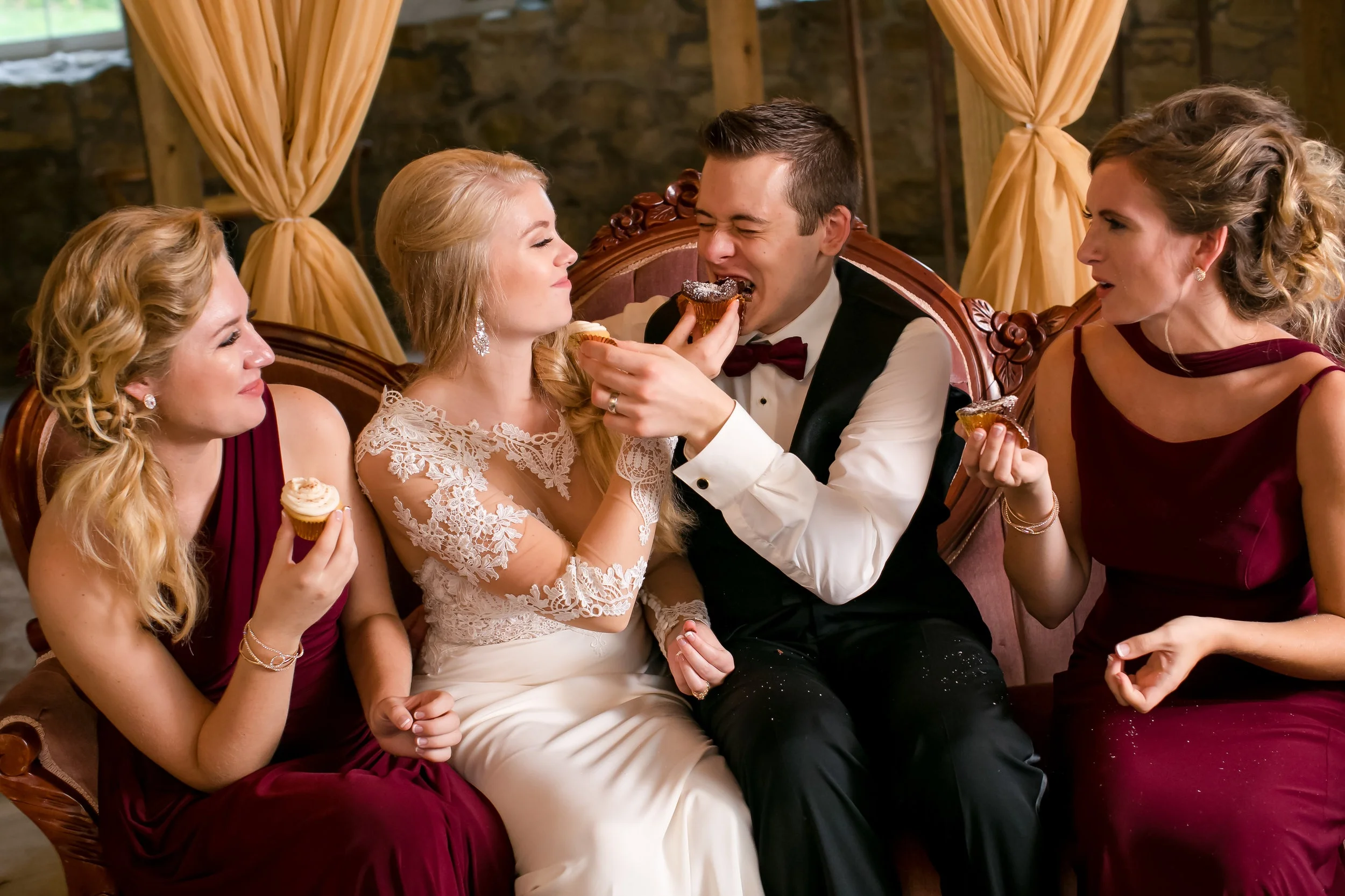 Enjoying wedding desserts with burgundy dresses and taupe draping backdrop