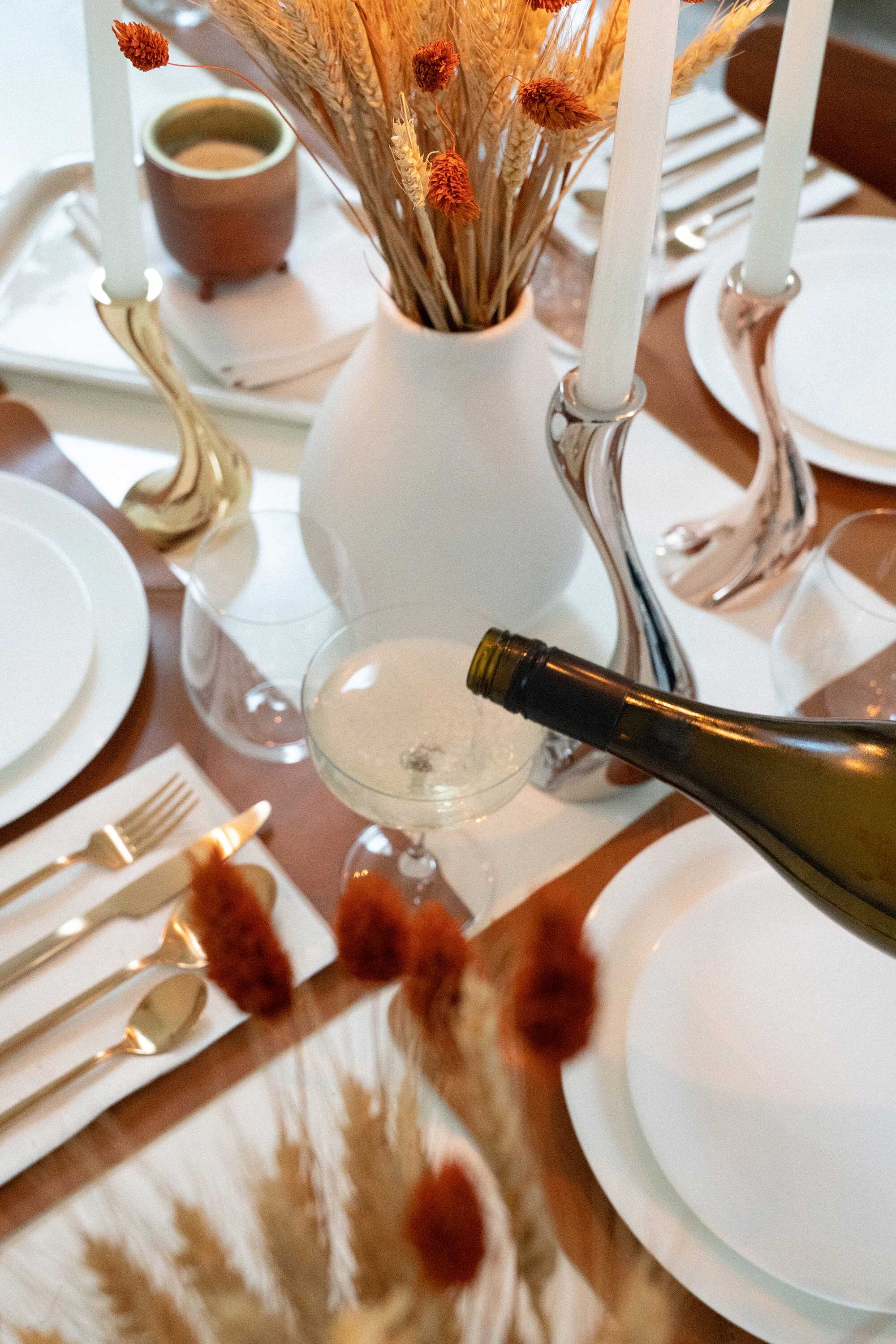 Thanksgiving table settings elegant gold. Sarah Butler of @sarahchristine Thanksgiving table settings featuring Georg Jensen Cobra Candleholder Set, tan leather placemats, and modern gold plated flatware with rustic dried flowers 18.jpg