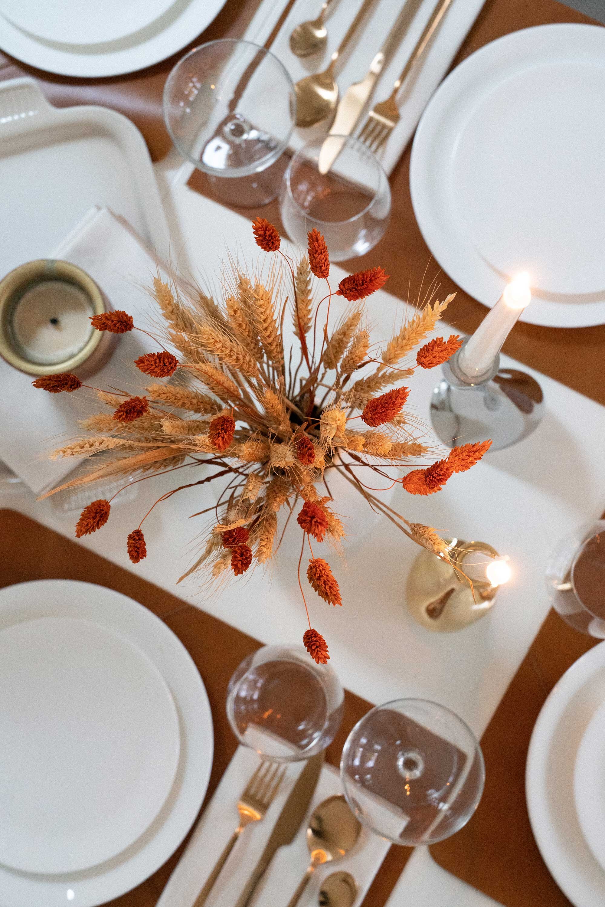 Thanksgiving table settings elegant gold. Sarah Butler of @sarahchristine Thanksgiving table settings featuring Georg Jensen Cobra Candleholder Set, tan leather placemats, and modern gold plated flatware with rustic dried flowers 9.jpg