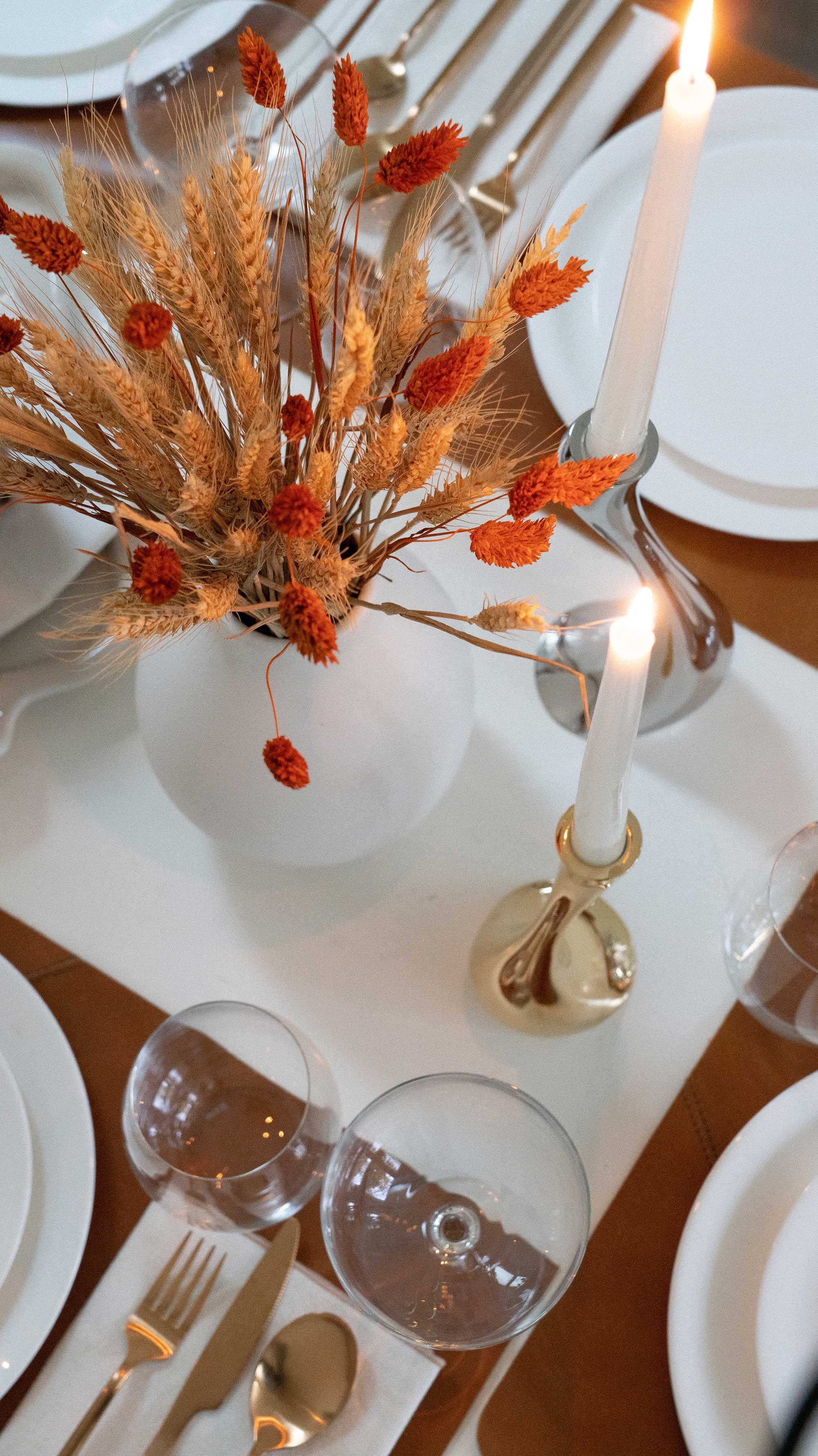Thanksgiving table settings elegant gold. Sarah Butler of @sarahchristine Thanksgiving table settings featuring Georg Jensen Cobra Candleholder Set, tan leather placemats, and modern gold plated flatware with rustic dried flowers 10.jpg