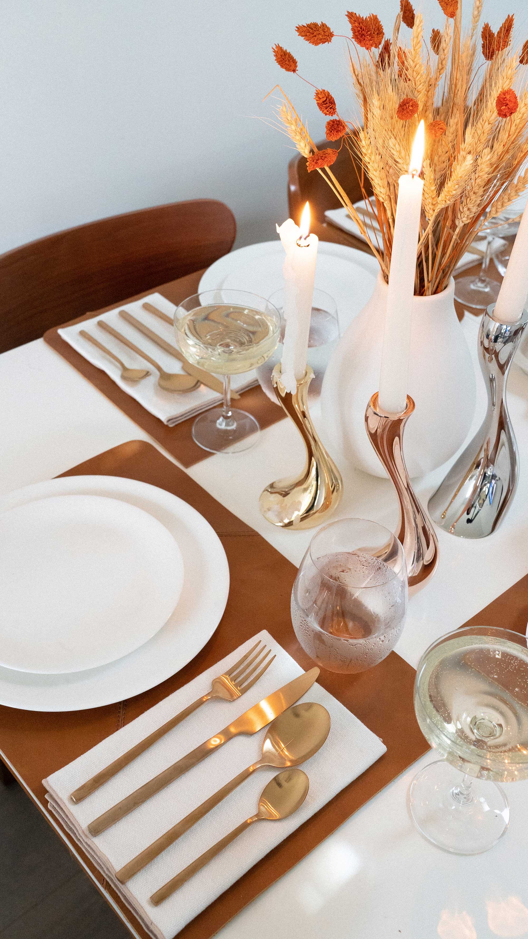 Thanksgiving table settings elegant gold. Sarah Butler of @sarahchristine Thanksgiving table settings featuring Georg Jensen Cobra Candleholder Set, tan leather placemats, and modern gold plated flatware with rustic dried flowers 39.jpg