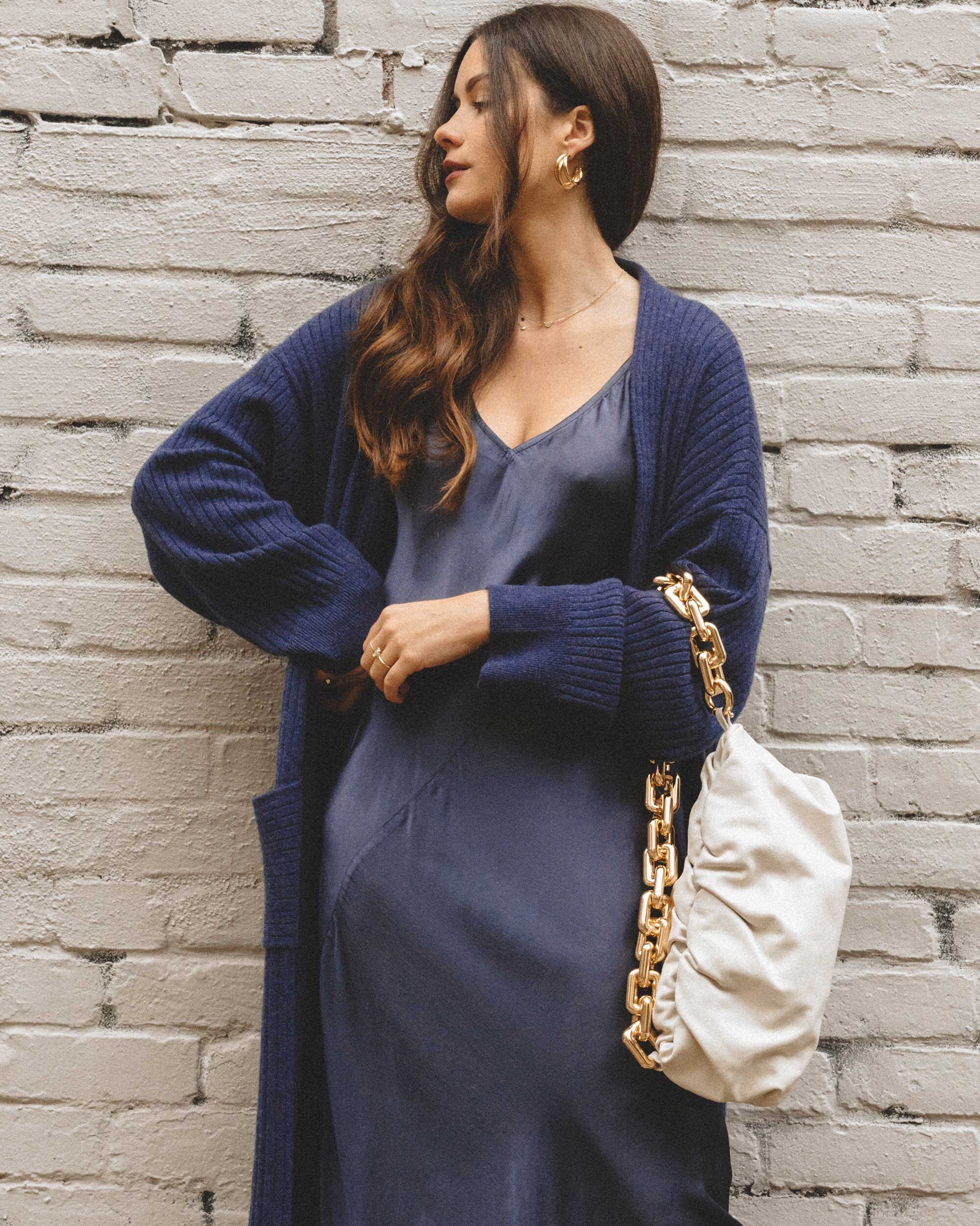 How to style a dress for winter. Sarah Butler of @sarahchristine wearing Line and Dot navy silk satin dress, Sablyn Long Cashmere Sweater, and Bottega Veneta The Chain Pouch Leather Clutch in Seattle, Washington -3.jpg