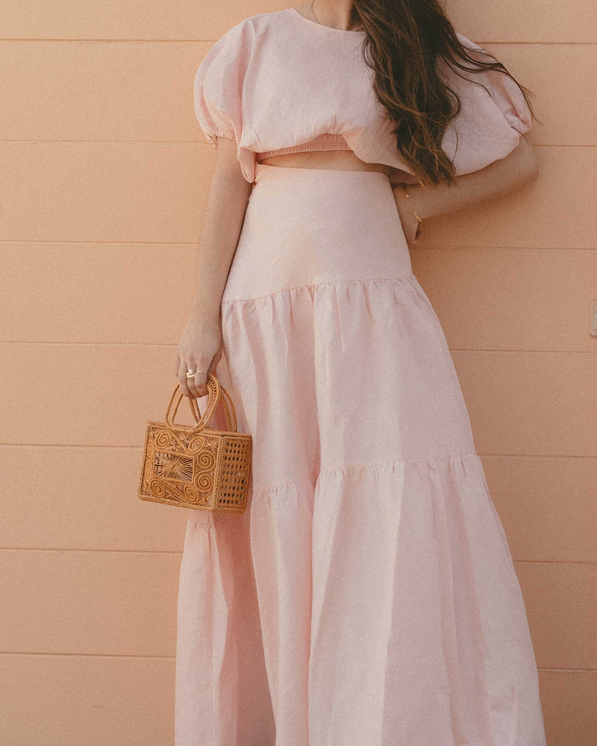 Cute Pink Spring Skirt Outfit Idea. Sarah Butler of @sarahchristine wearing  Mossman Daybreak Pink Linen Crop Top and Pink Linen Asymmetrical Tiered Skirt in Newport Beach, California - 2.jpg