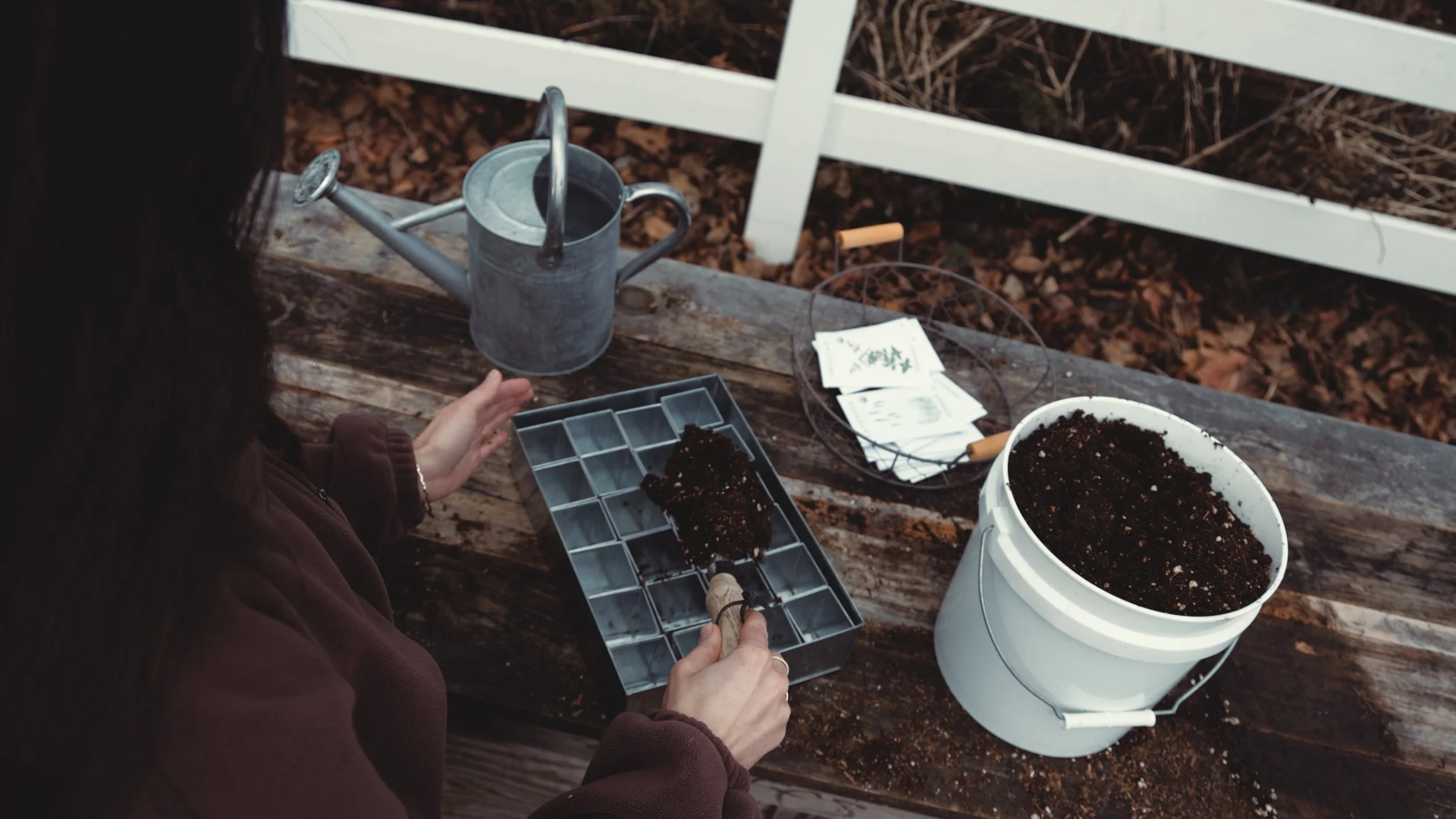 Seed starting supplies on a wooden table for February flower farm planning