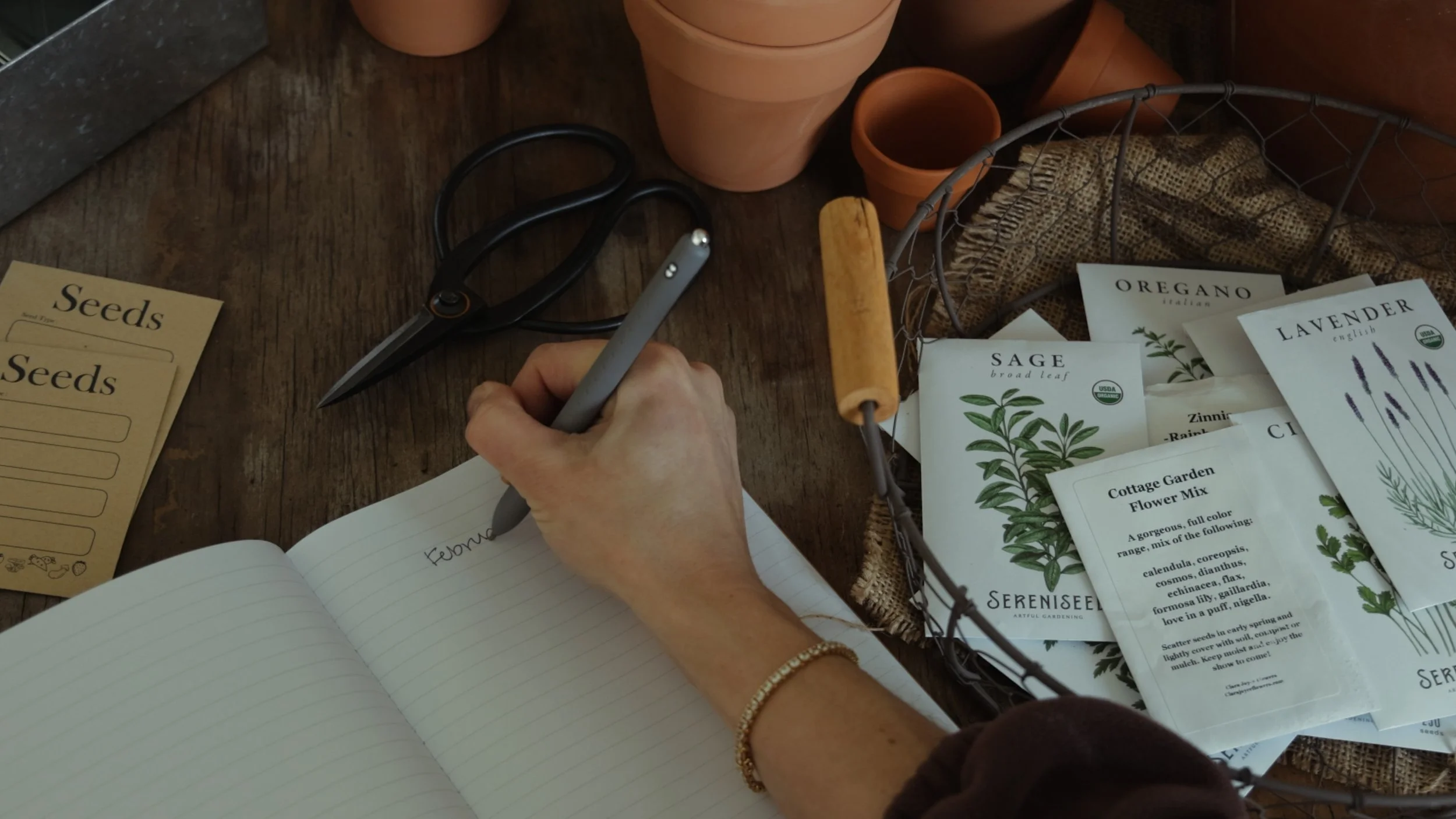 Seed starting supplies on a wooden table for February flower farm planning