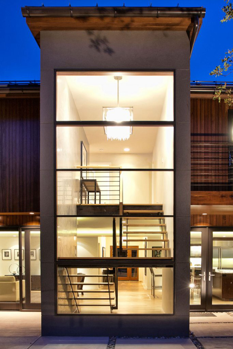  Two full stories of windows encase a modern sleek staircase. 