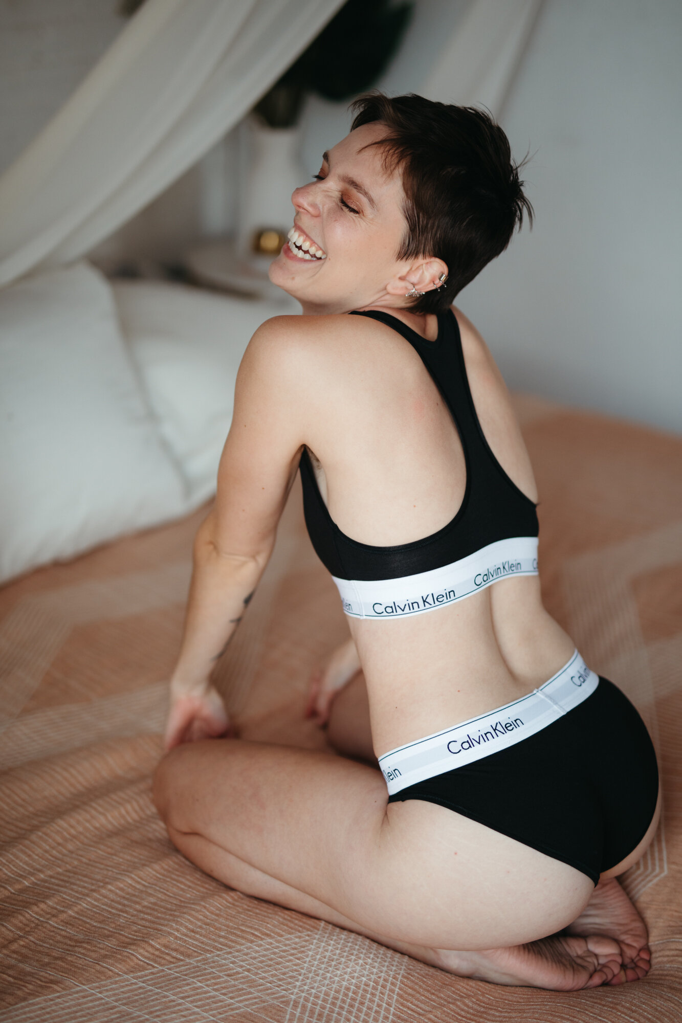 Queer babe in a black Calvin Klein underwear set laughing
