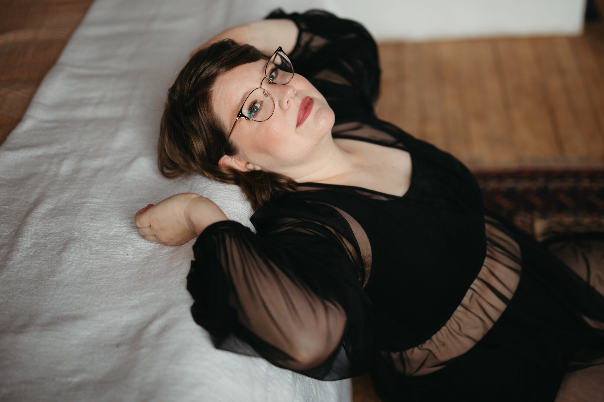 Boudoir photo of agender person with red lipstick