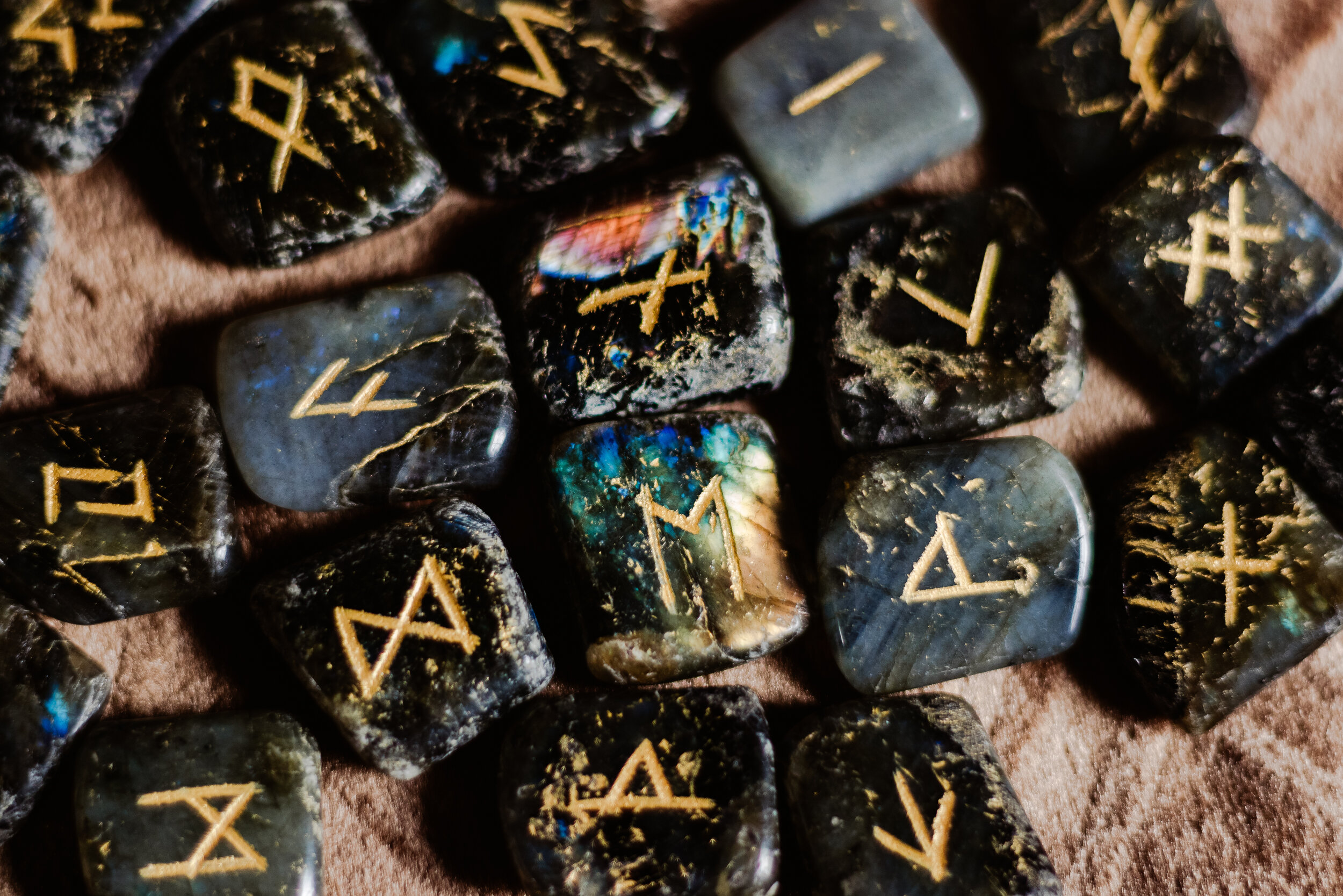 I've been trying to decipher the runes on Odin's tattoos for a while now  but the futhark system is extremely confusing and I haven't been able to  come up with anything. Does