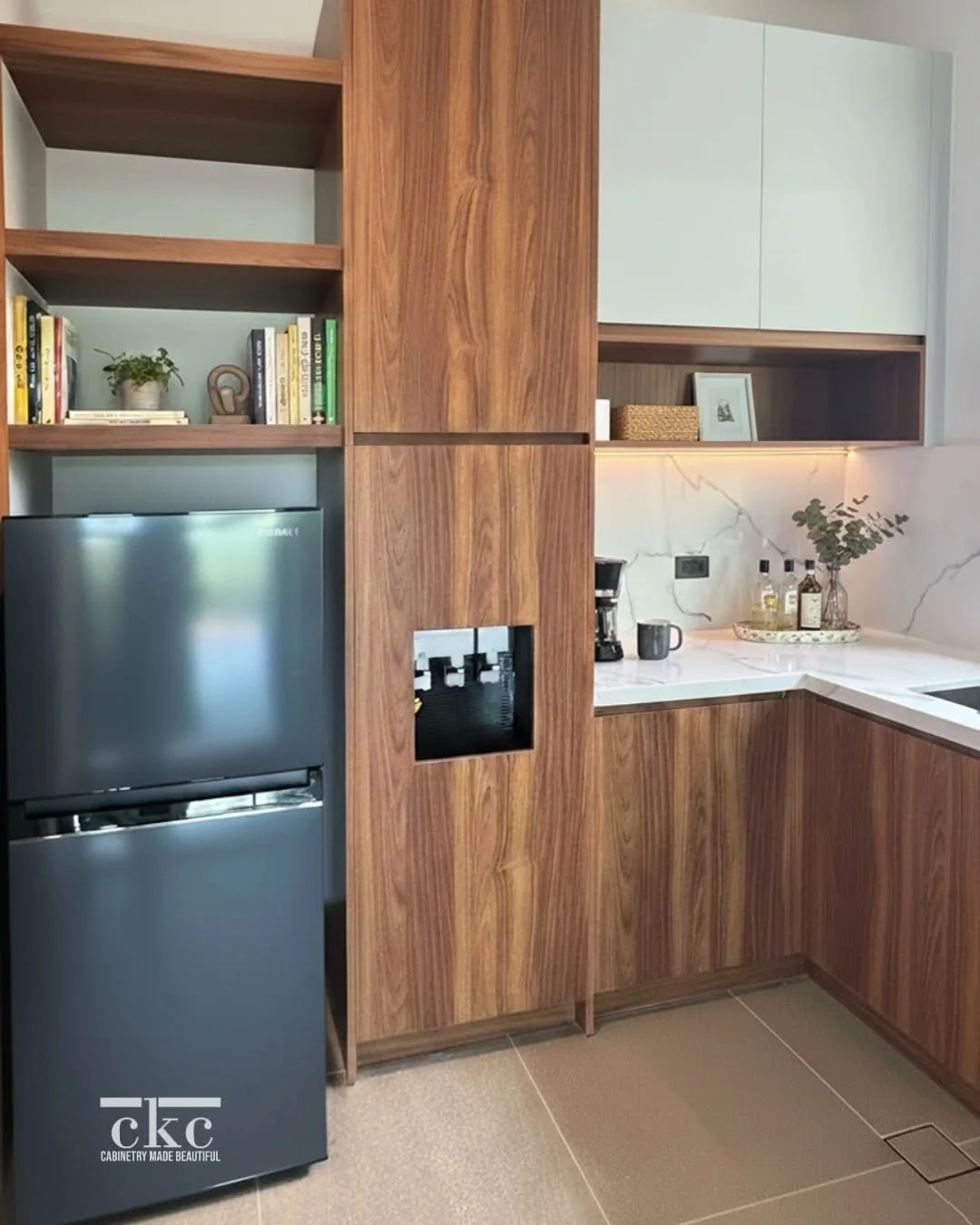 Obsessed with how this kitchen corner came together! 🤍 

The beautiful wood-grain finish of these custom kitchen cabinets provides so much hidden storage and a sleek look. Perfectly balanced by the bright countertops and open display shelves for you