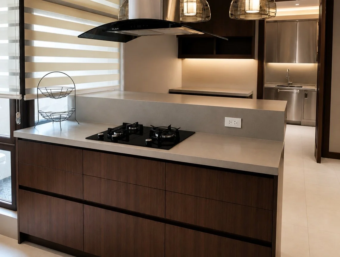 Modern kitchen island with a light stone countertop, dark wood cabinetry, pendant lighting, and integrated storage in a contemporary Philippine home.