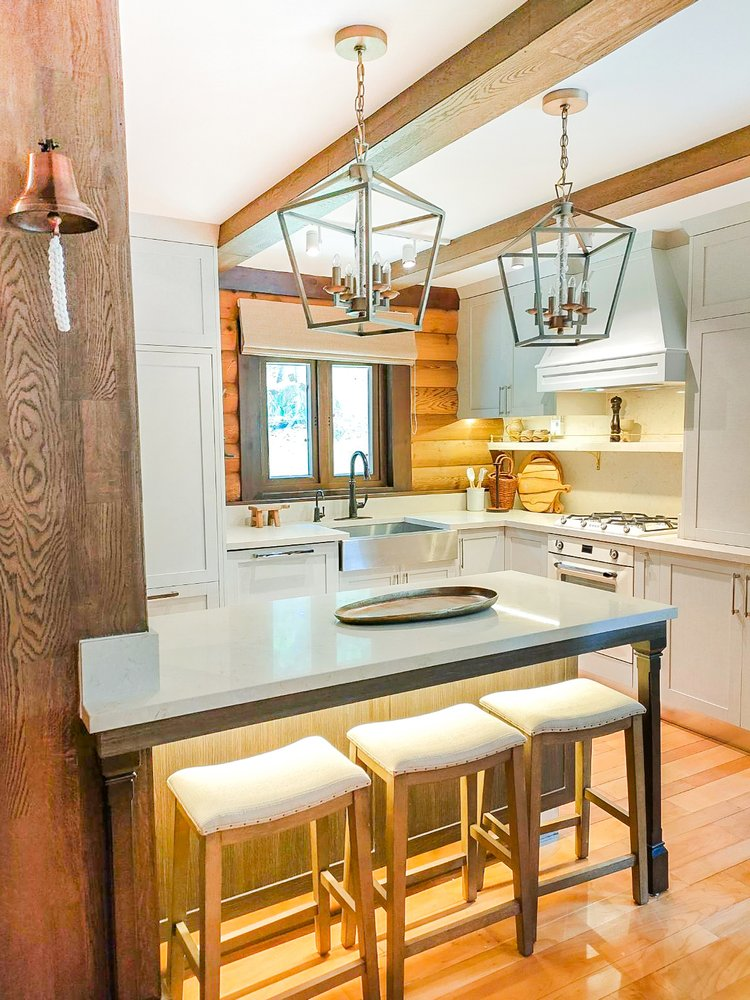 Luxury custom kitchen cabinets with a large island, wood ceiling beams, and integrated storage in a Tagaytay Highlands home.