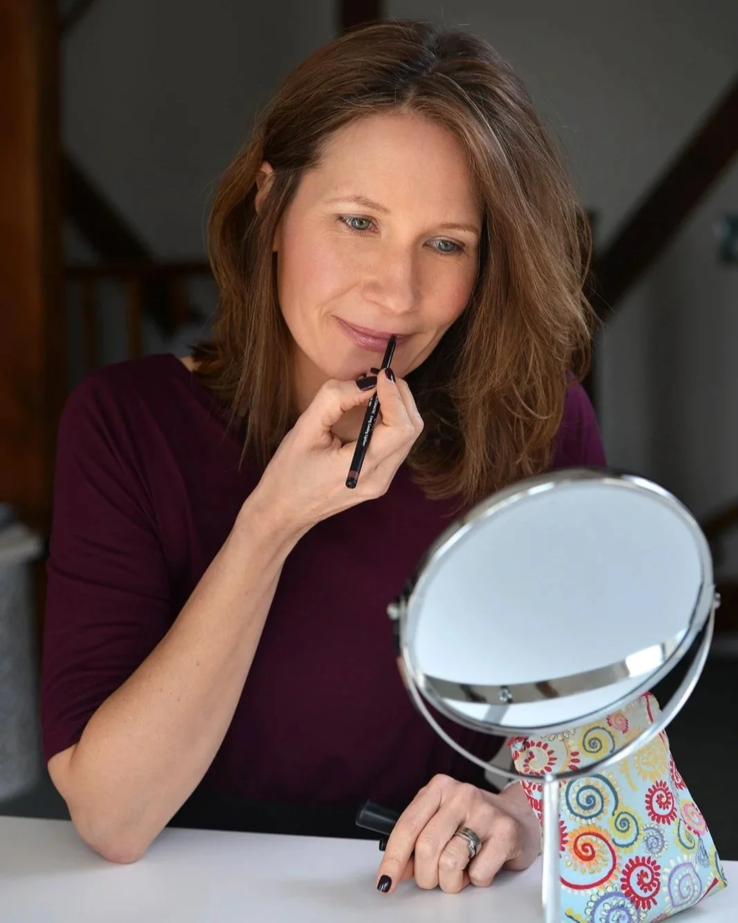 Jane applying make-up in desk mirror