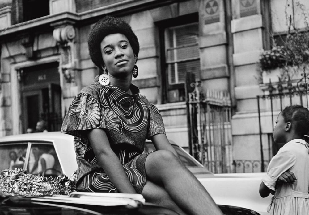 Kwame-Brathwaite-Black-Is-Beautiful-Grandassa-Model-on-car-during-Garvey-Day-celebration-Harlem-ca.-1968.jpg