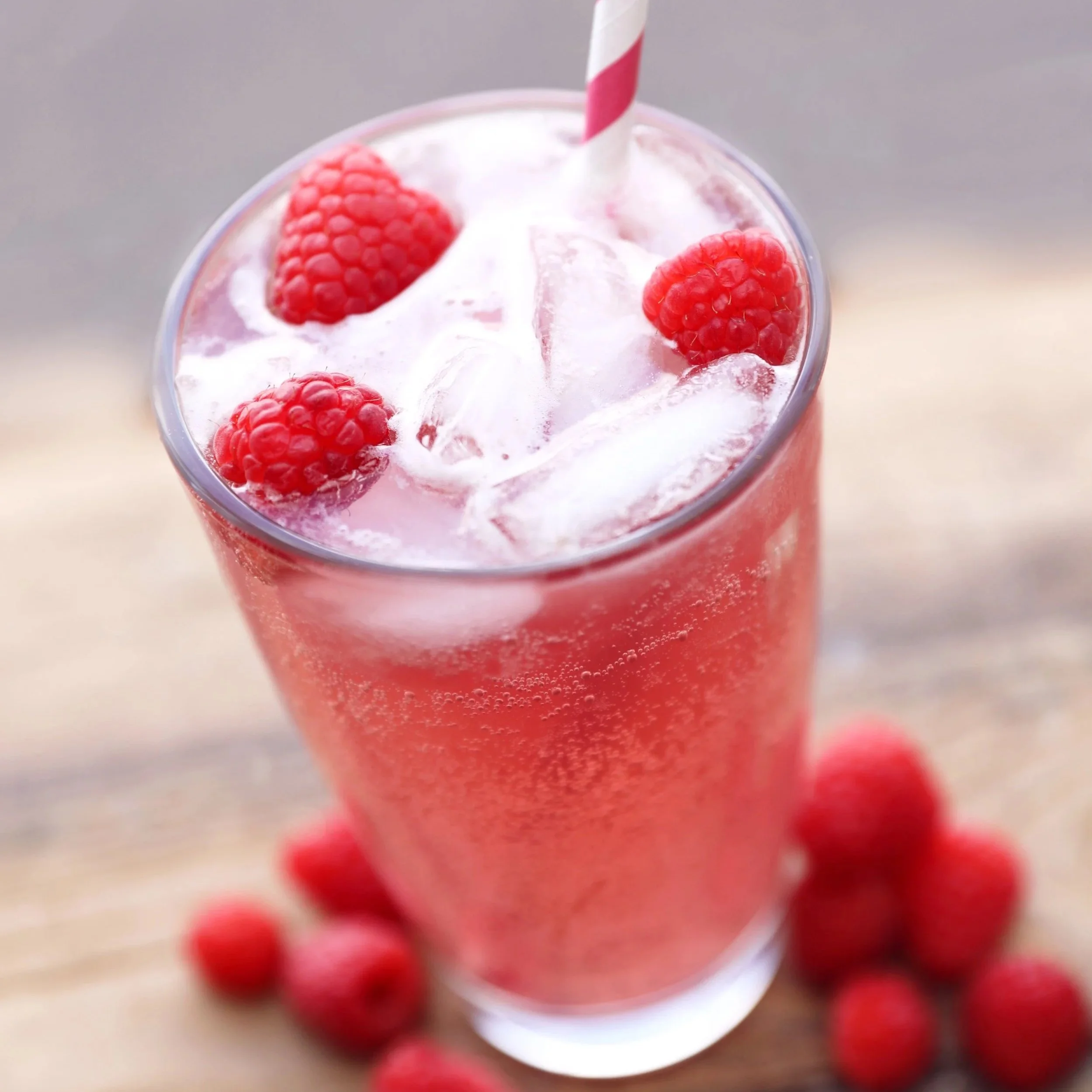 Fizzy raspberry drink in glass, made with real raspberry syrup.