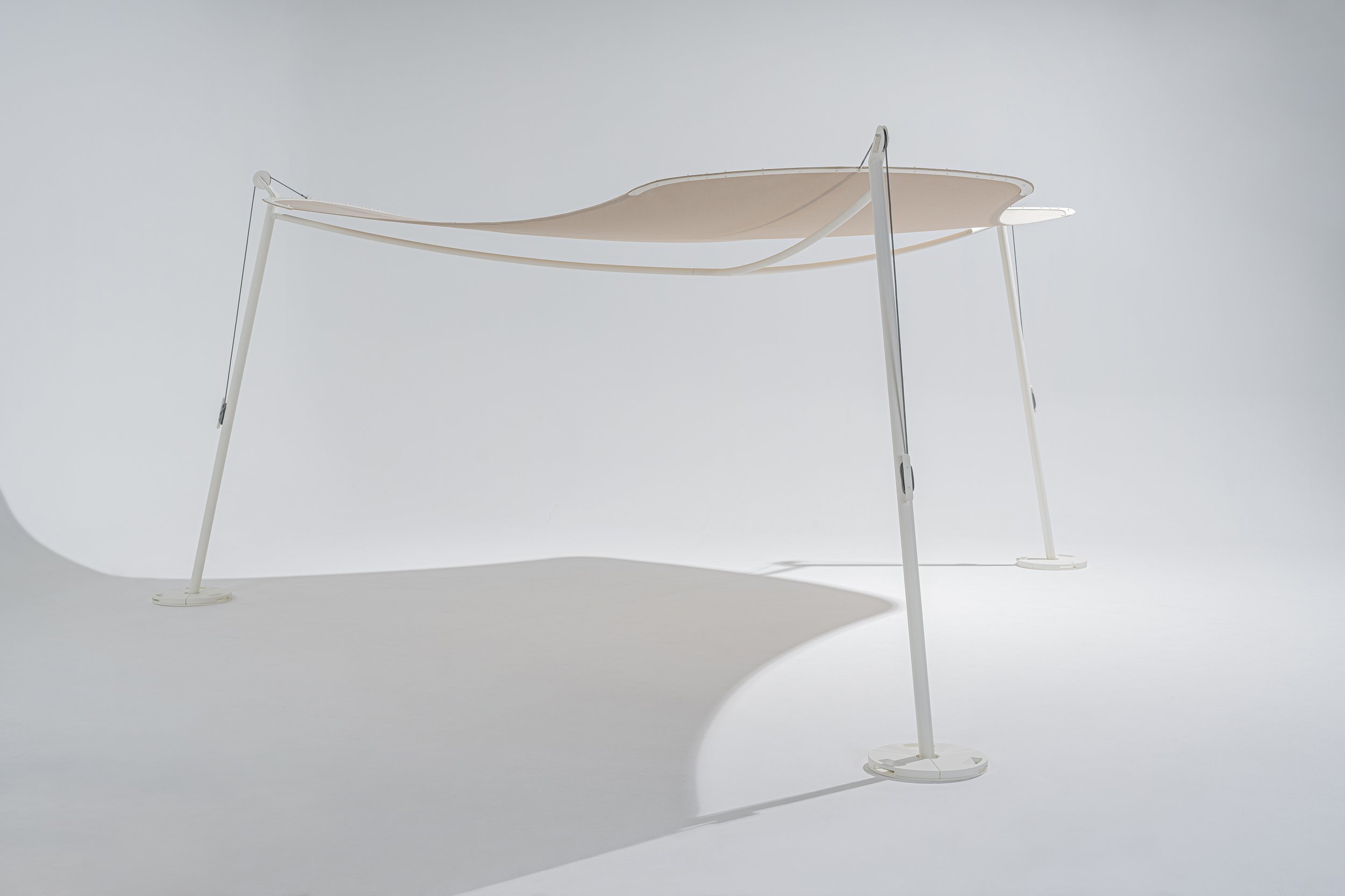  The shape of the Nuer shade has been designed for different outdoor uses – a radially symmetrical, tripartite shape that adapts optimally to many situations. Stability and weather resistance are achieved by incorporating three pillars inspired by th