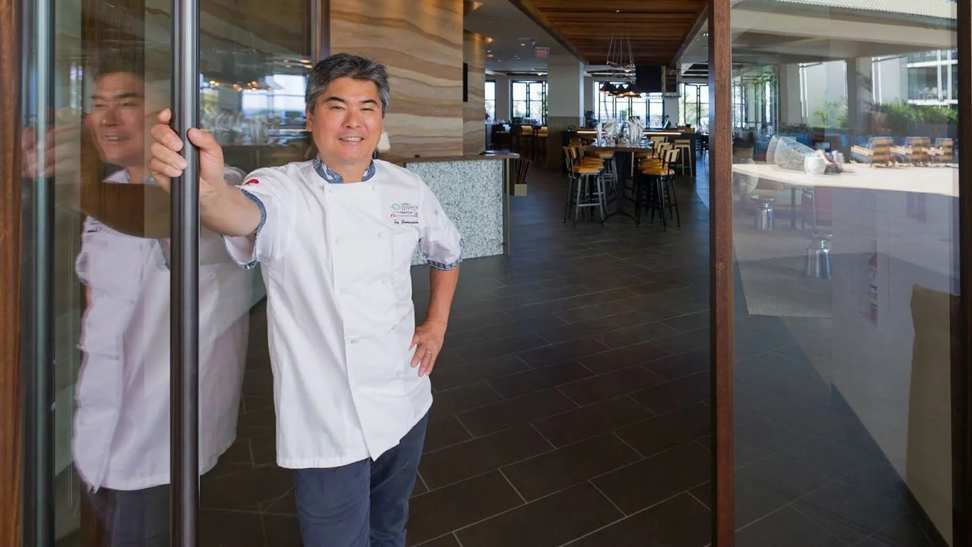 One of Hawaii’s best-known chefs, Roy Yamaguchi, stands in the doorway of Humble Market Kitchin. Located in South Maui, it’s Yamaguchi’s newest creation.