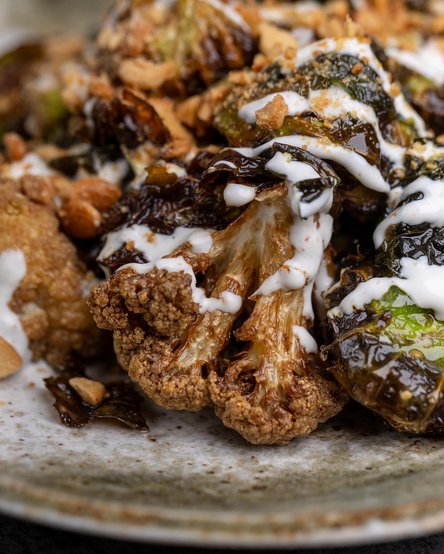 Crunch and Savor: Crispy Brussels and cauliflower mingle with toasted cashews and a zesty Dijon vinaigrette, all brought together with Za&rsquo;atar Greek yogurt!