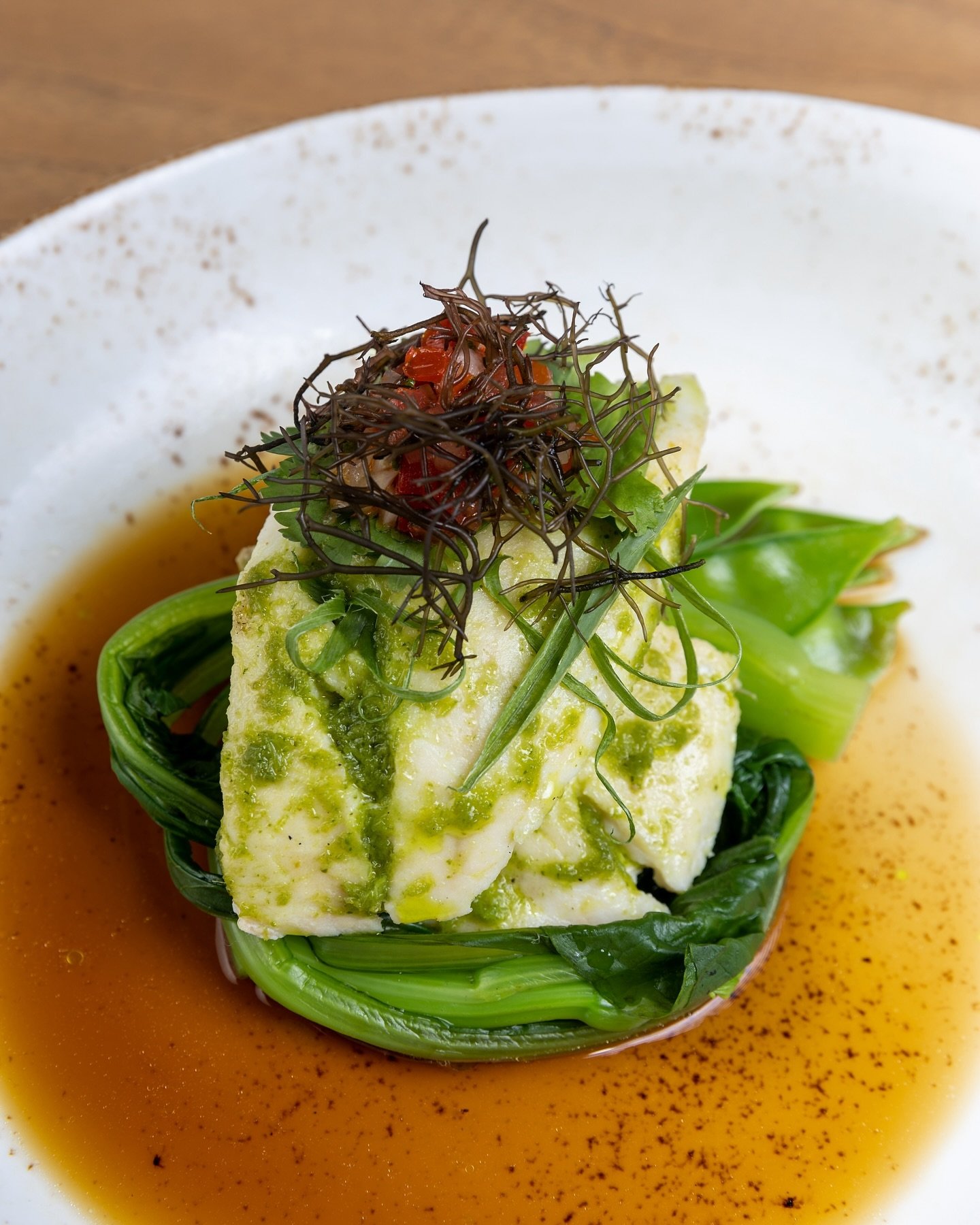 At Roy&rsquo;s&reg; Waikoloa, our Jade Pesto Steamed Snapper is served with Chinese soy, snow peas, and lomi offering a unique blend of textures and flavors, creating a refreshing and light dining experience.