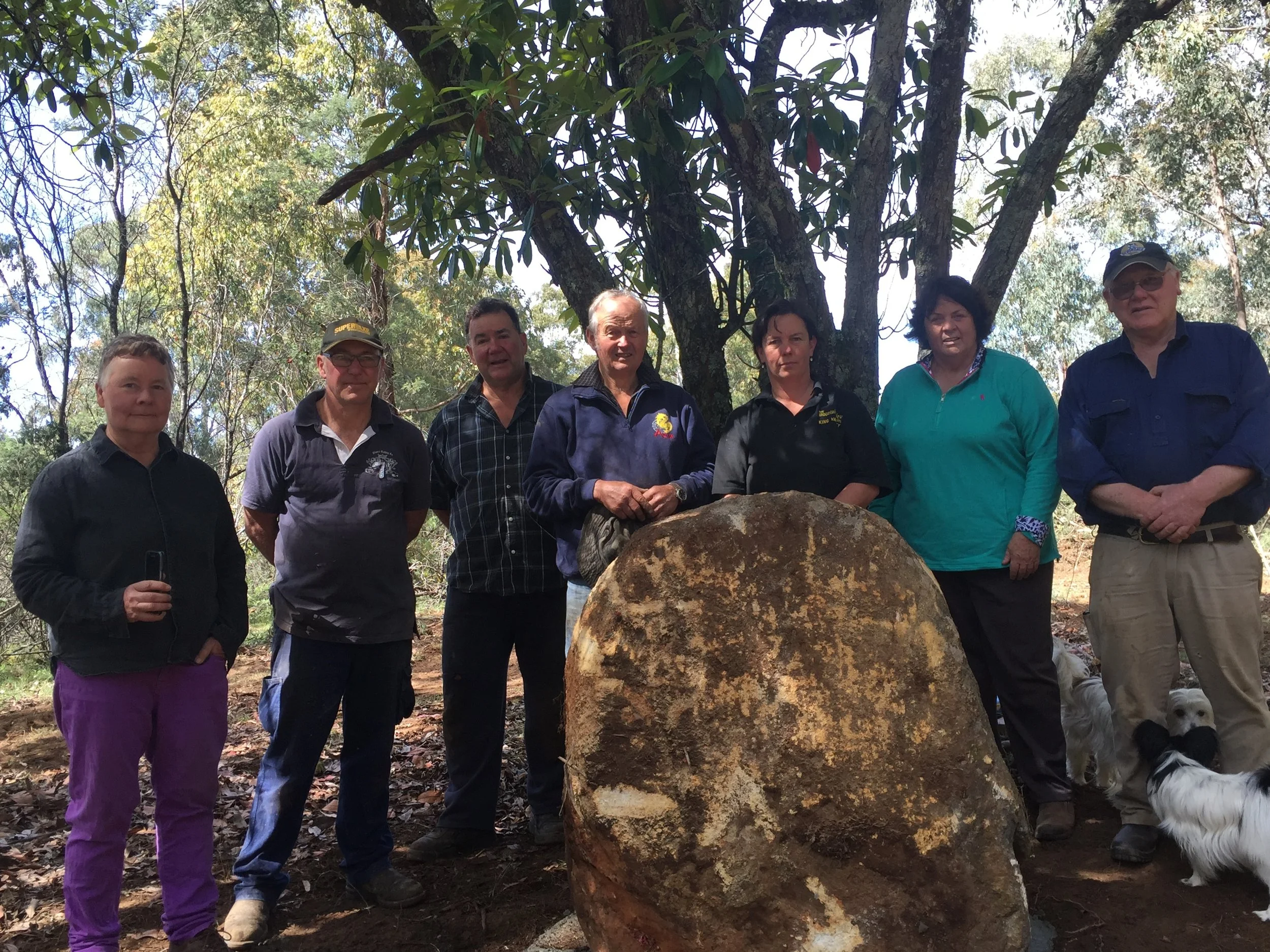 Setting a rock before installing the school site plaque