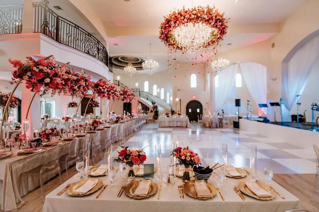 Luxurious wedding reception ballroom at Knotting Hill Place decorated with  uplighting, round tables with linens, chandelier lighting, and dance floor  accommodating 300+ guests
