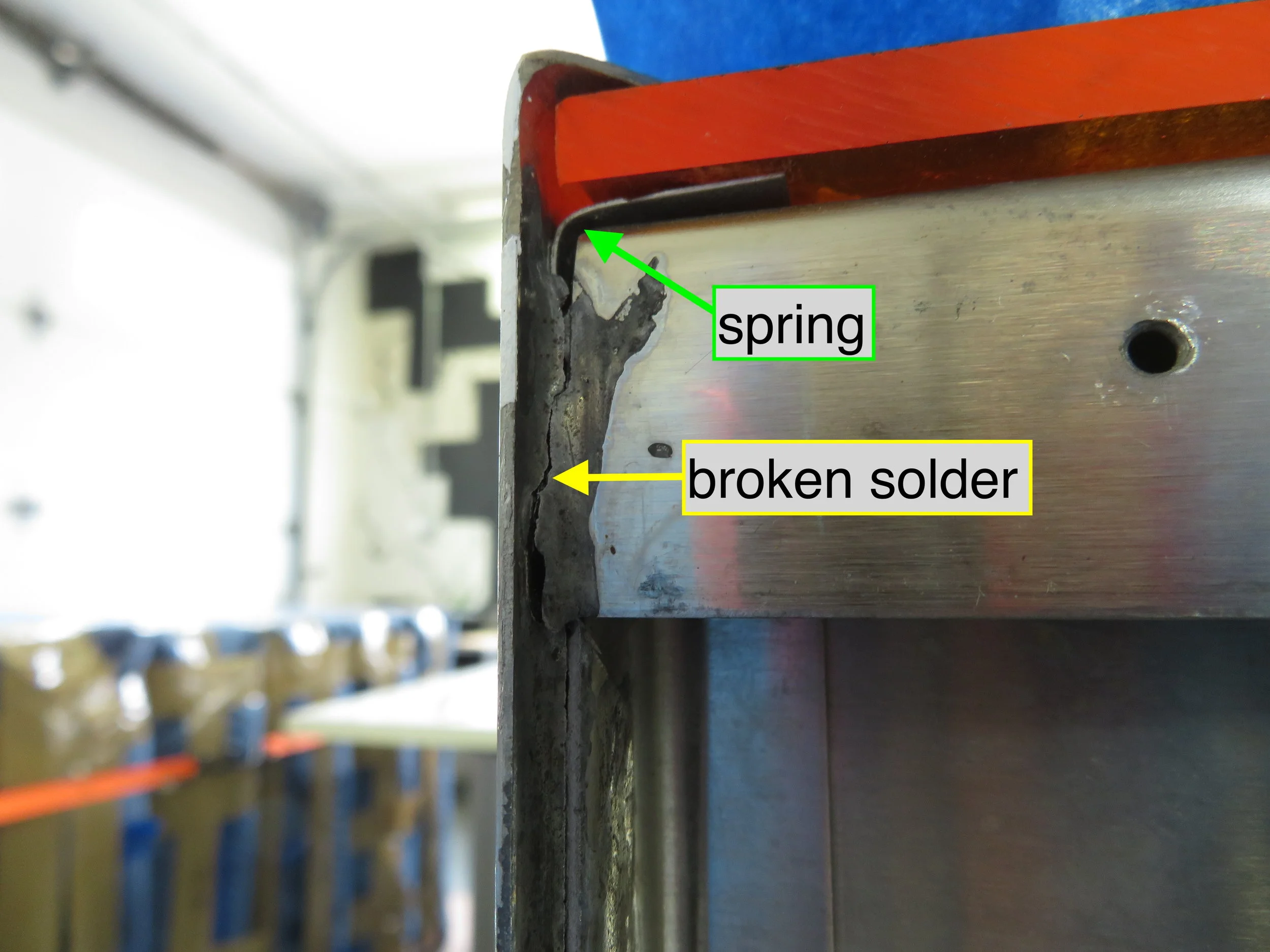 Spring holding acrylic in place and broken solder join