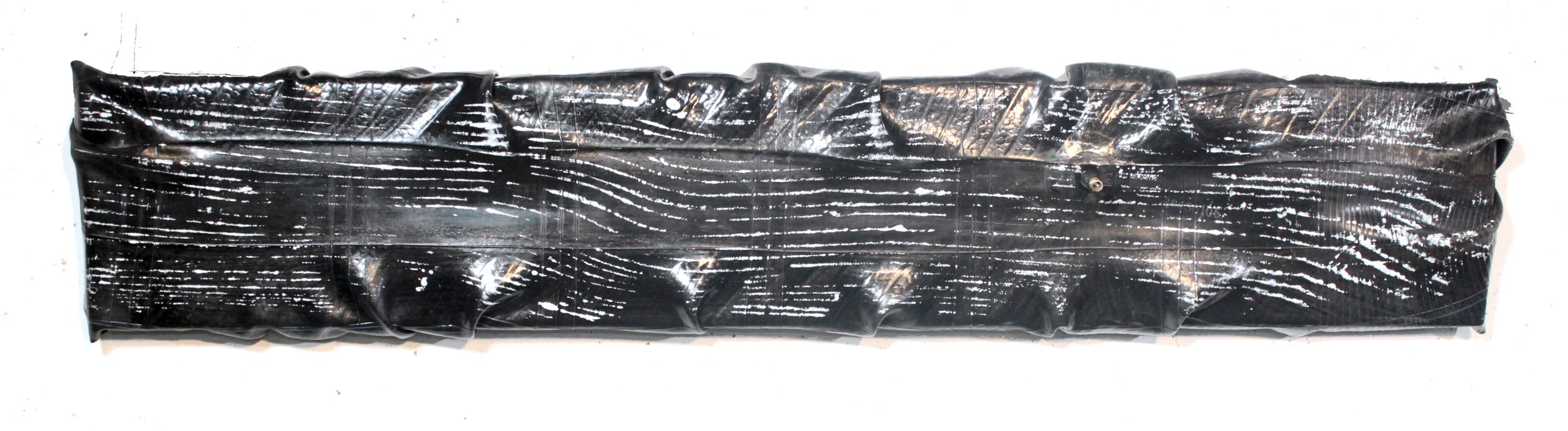  “Passages,” 2022, acrylic and spray lacquer on stretched tractor tire tube, 8”x36” 