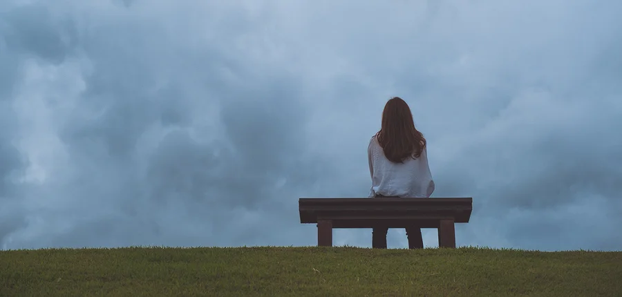 bigstock-A-Woman-Sitting-Alone-On-A-Woo-248874154.jpg