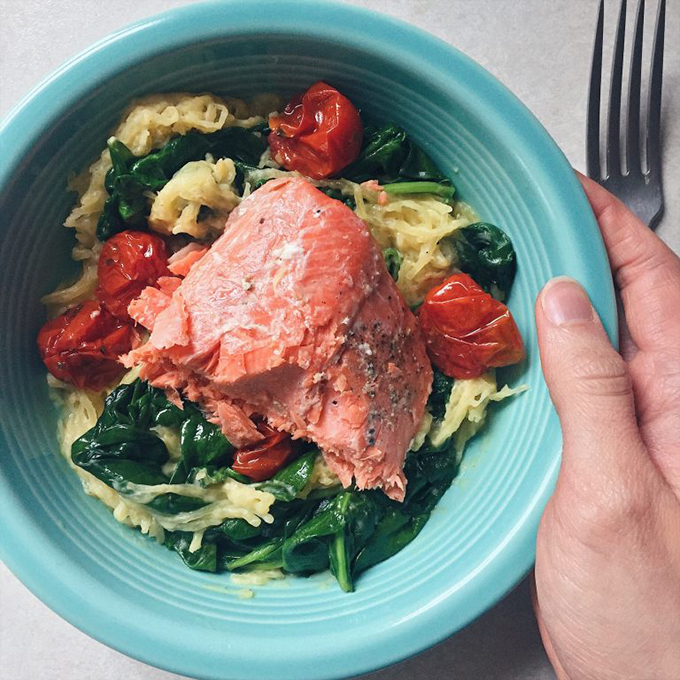 Sous vide salmon with roasted tomatoes, spinach, and spaghetti squash “alfredo”